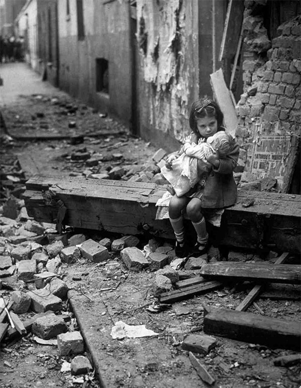 Fetita englezÄƒ cu o papusa aÈ™ezata pe ruinele caselelor distruse Ã®n bombardamentele. 1940.